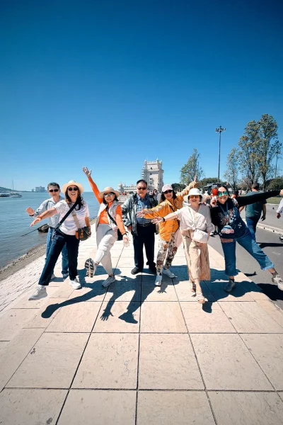 Tour group posing on the riverside promenade by Belém Tower in Lisbon